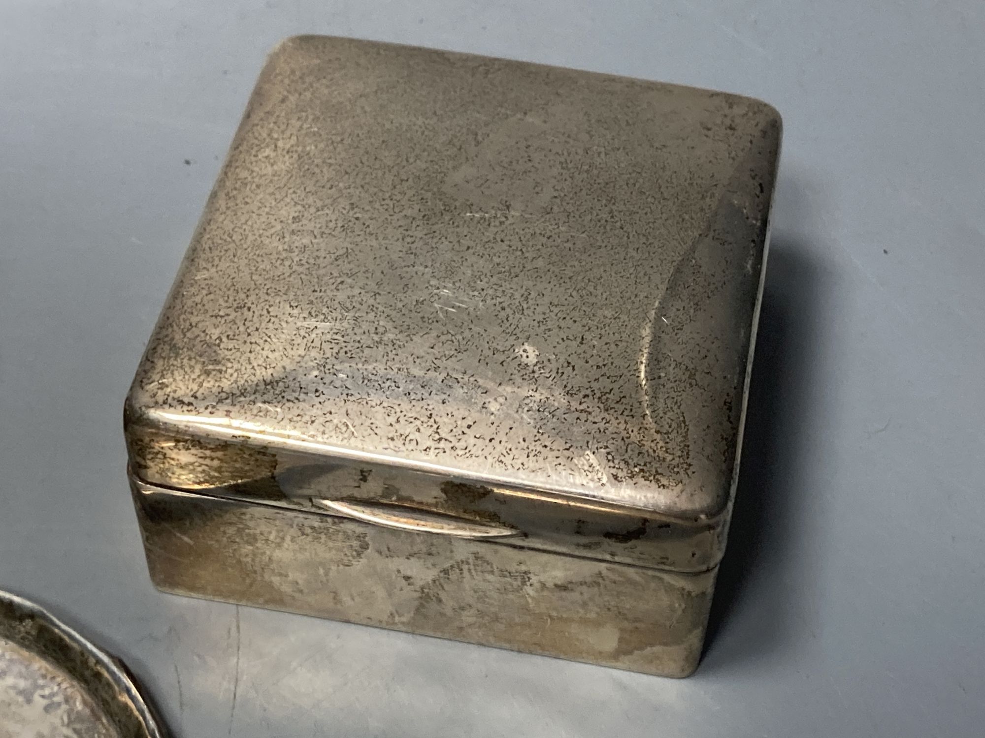 A silver cigarette box, silver cigarette case, four vestas including two silver, a continental dish and a toilet jar.